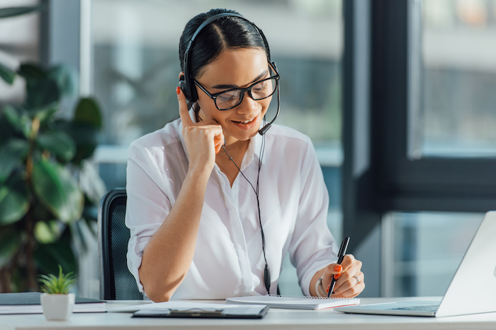 woman at desk with headphones